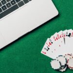 Cartes à jouer et jetons sur une table de casino à l'aide d'un ordinateur portable